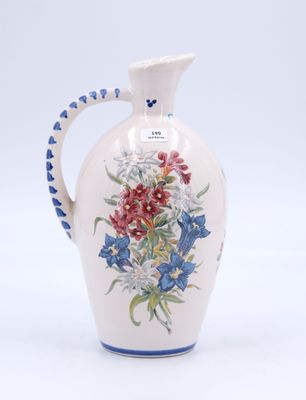 un vase blanc avec une anse bleue et des fleurs peintes dessus