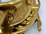 a gold clock sitting on top of a white table