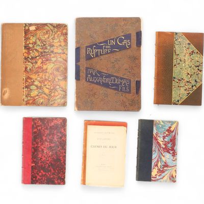 plusieurs vieux livres sont alignés sur une surface blanche