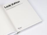 an open book on a white surface with a black and white logo