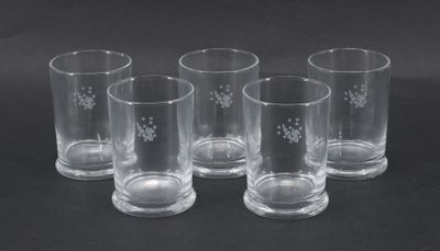 six verres transparents décorés, posés sur un fond noir