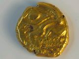 a gold coin that is sitting on a white surface