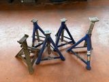 three blue jack stands sitting on the floor in a garage