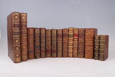 several old books are lined up in a row on a white surface