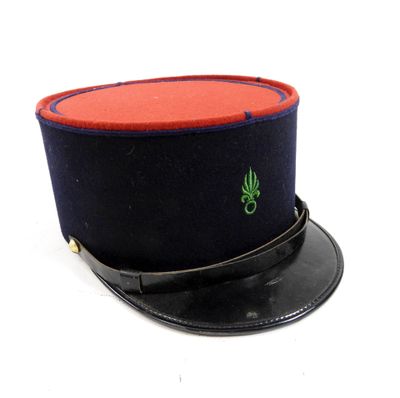 un chapeau noir avec un bord rouge et une feuille verte dessus