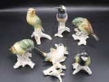 sept figurines d'oiseaux posées sur une table