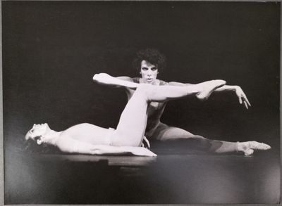 photographie en noir et blanc d'une femme faisant le grand écart sur le sol