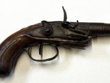 un pistolet posé sur une surface blanche