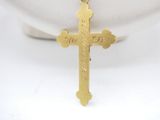 a close up of a gold cross on a white bowl