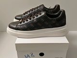 Les baskets noires et marron sont posées sur une boîte blanche.