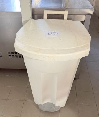 une poubelle blanche posée au milieu d'une cuisine