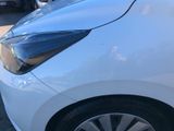 a close up of a white car parked in a parking lot