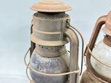 two old lanterns sitting next to each other on a white surface