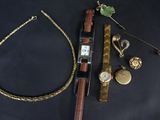 une photo montrant une montre, un bracelet et d'autres bijoux posés sur une table