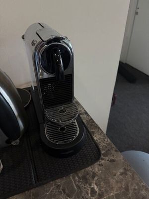 une cafetière en argent posée sur un plan de travail à côté d'une autre cafetière en argent
