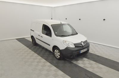 La camionnette blanche est garée dans le garage de l'immeuble.