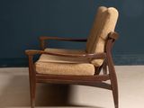 the chair is made of wood and has a tan upholstered seat