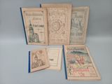 several old books sitting on top of a table next to each other