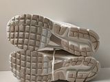 pair of white sneakers with grey soles sitting on a white surface