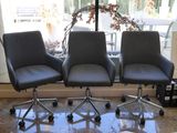 three chairs that are sitting in front of a window