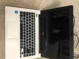 an open laptop computer sitting on top of a floor next to a charger