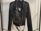 une veste en cuir noir suspendue à un portant dans une pièce