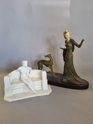 une statue représentant une femme et un chien posée sur une table