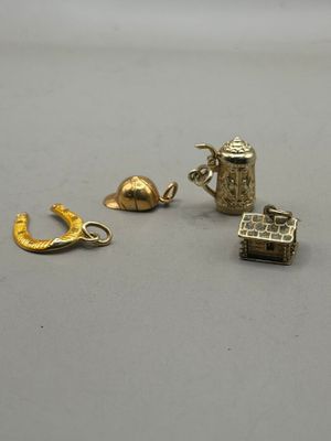 three gold charms are sitting on a table next to each other