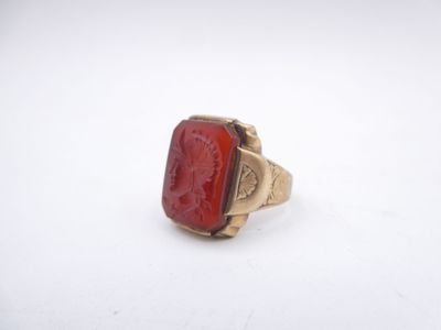 a close up of a red stone ring on a white surface