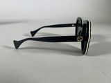 chanel sunglasses with black frames and gold details on a white surface