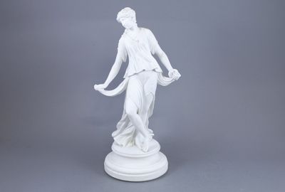 a white statue of a woman holding a basket on a pedestal