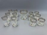 un lot de douze verres à pied avec un bord argenté posés sur une table