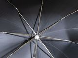 a black umbrella that is open on a sunny day