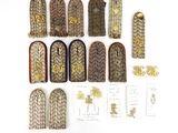 Plusieurs types d'uniformes militaires sont disposés sur une surface blanche