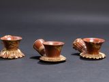 three small vases sitting on top of a table next to each other
