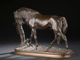 statue en bronze représentant un cheval, posée sur un socle en bois avec un fond noir