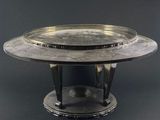 an image of a silver plate on a stand on a black background