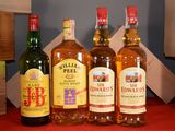 Plusieurs bouteilles de différentes sortes d'alcool sont alignées sur une table