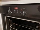 a black oven with a timer on it in a kitchen