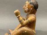 figurine of a man sitting on the ground holding a cup