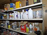 de nombreuses bouteilles et récipients posés sur une étagère dans une pièce