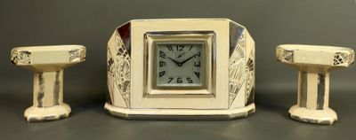 a small clock sitting next to two small stools
