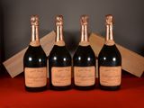 four bottles of champagne are lined up on a red table
