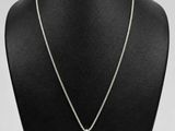 a necklace on a mannequin display with a white background