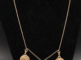 un collier en or orné d'une croix et de quatre pièces