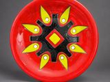 a red plate with yellow and black designs on it