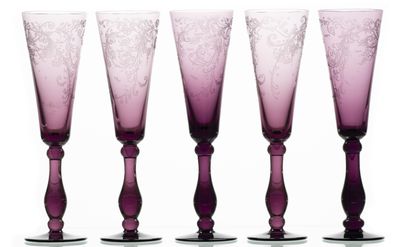 quatre verres à vin violets posés les uns à côté des autres sur une surface blanche
