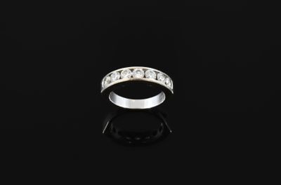 a white gold and diamond ring on a black surface