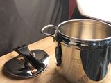 une grande casserole posée sur une table en bois, à côté d'un couteau