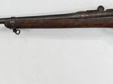 a rifle mounted on a wall with a white background